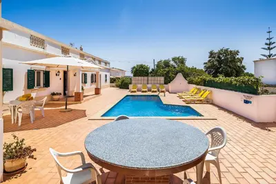 a patio with a table and chairs and a pool at Casa da Bia by OCvillas in Albufeira