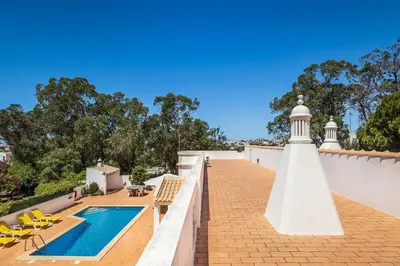a lighthouse on the roof of a house with a pool at Casa da Bia by OCvillas in Albufeira