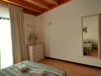a bedroom with a bed and a large mirror at Casa Flor de Sal - moradia no Centro de Faro! in Faro