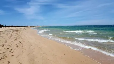 a sandy beach with the ocean in the background at Casa Flor de Sal - moradia no Centro de Faro! in Faro