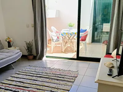 a living room with a table and chairs and a table at Casa Flor de Sal - moradia no Centro de Faro! in Faro