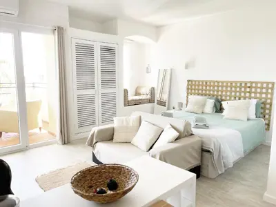 a living room with a couch and a bed at Seaview Studio - 10 Min. Beach, Private Condo, Pool, Grill & Free Parking in Albufeira
