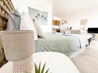 a bedroom with two beds and a living room at Seaview Studio - 10 Min. Beach, Private Condo, Pool, Grill & Free Parking in Albufeira