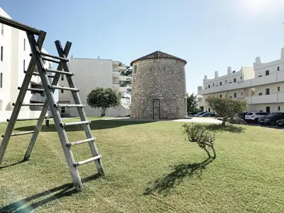 a ladder sitting in a field with a building at Seaview Studio - 10 Min. Beach, Private Condo, Pool, Grill & Free Parking in Albufeira