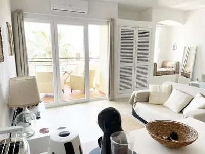 a living room with a couch and a table at Seaview Studio - 10 Min. Beach, Private Condo, Pool, Grill & Free Parking in Albufeira