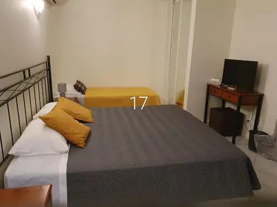a bedroom with a bed with yellow pillows and a television at Hospedaria do Almargem in Quarteira
