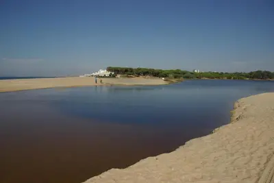 a body of water next to a sandy beach at Hospedaria do Almargem in Quarteira