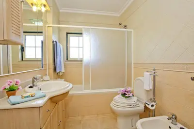 a bathroom with a sink and a toilet and a mirror at Villa João Paulo in Albufeira