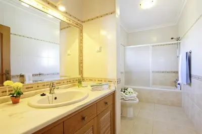 a bathroom with a sink and a toilet and a mirror at Villa João Paulo in Albufeira