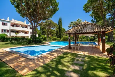 a swimming pool with a gazebo next to a house at Vilamoura Oasis Family Duplex in Vilamoura