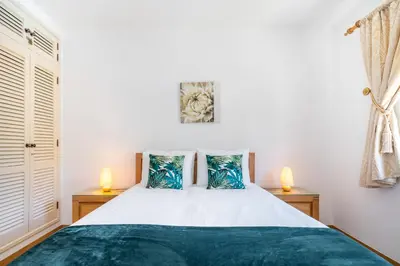 a bedroom with a large bed with two lamps at Vilamoura Oasis Family Duplex in Vilamoura