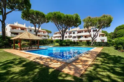 a villa with a swimming pool in front of a building at Vilamoura Oasis Family Duplex in Vilamoura