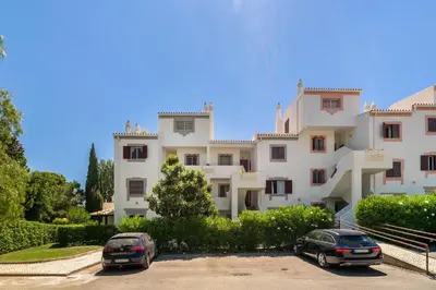 two cars parked in a parking lot in front of a building at Vilamoura Oasis Family Duplex in Vilamoura