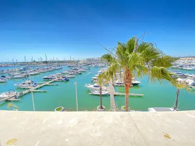 a marina with palm trees and boats in the water at Vilamoura Marina Mezzanine Loft in Vilamoura
