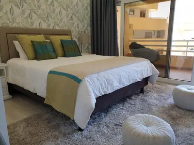 a bedroom with a large bed and a large window at Marina Mar Vilamoura Apartment in Vilamoura