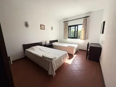 a bedroom with a bed with a red blanket on it at Villa Azevedo in Vilamoura