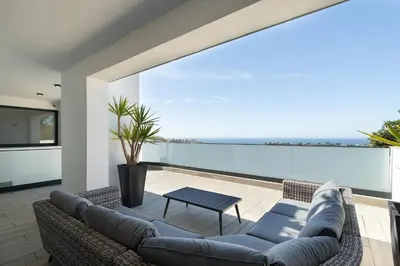 a swimming pool with chairs and a house at Villa Tropicana in Albufeira
