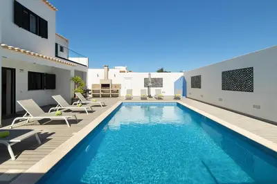 a villa with a swimming pool and patio furniture at Villa Tropicana in Albufeira