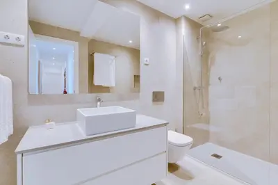 a bathroom with a sink and a toilet and a shower at AL - Apartamento Egas Moniz in Quarteira