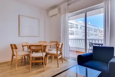 a living room with a table and chairs and a couch at AL - Apartamento Egas Moniz in Quarteira