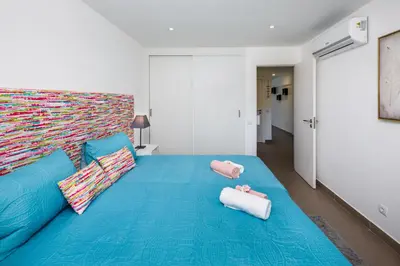 a large blue bed with two pink pillows on it at AlbufeiraMar Apartment in Albufeira