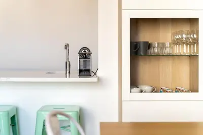 a kitchen with a cupboard with dishes in it at AL - Apartamento Vidal Mar in Quarteira