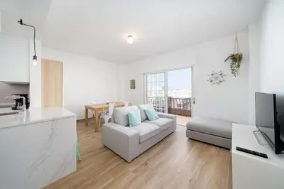 a white living room with a couch and a kitchen at AL - Apartamento Vidal Mar in Quarteira