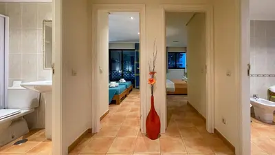 a bathroom with a sink and a red vase at T2 Apartment Falesia Beach Albufeira in Roja- Pé