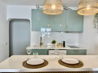 a kitchen with two plates and glasses on a table at White Sand Apartments Downtown Albufeira in Albufeira