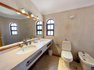 a bathroom with two sinks and a toilet and a mirror at Villa Cristina 9 in Albufeira