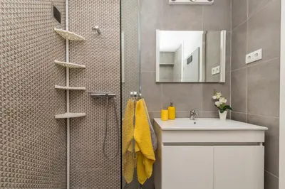 a bathroom with a shower with a sink and a mirror at Casa da Praia dos Pescadores in Albufeira