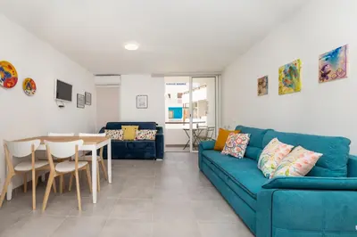 a living room with a blue couch and a table at Casa da Praia dos Pescadores in Albufeira