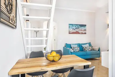 a living room with a table and a blue couch at Nuances do Oceano by OCvillas in Albufeira
