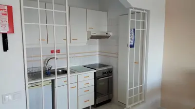 a kitchen with white cabinets and a sink and a stove at Albufeira 603 in Albufeira