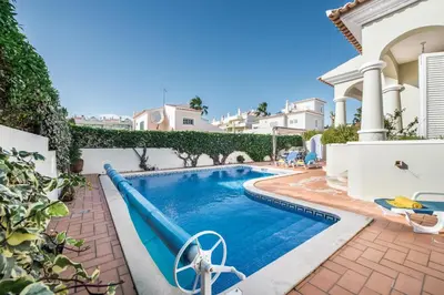 a swimming pool in front of a house at Rosal 27 by Algarve Villa Holidays in Albufeira