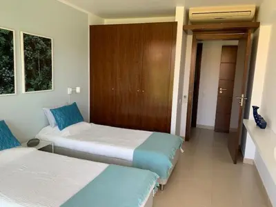 a room with two beds and a hallway at Ambassador Salgados Beach Suites in Albufeira