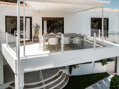 a kitchen and dining room with a table and blue chairs at Vila Hibisco by Garvetur in Vilamoura