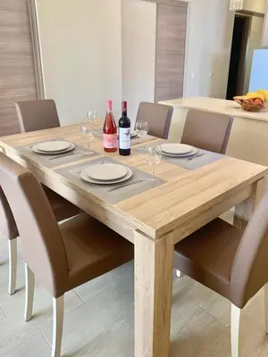 a wooden table with chairs and wine bottles and glasses at 125 Oliveiras Terraces in Albufeira