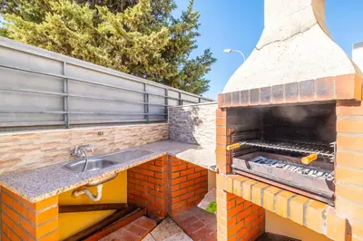 a brick outdoor kitchen with a sink and a grill at Cozy villa with pool and Barbecue in Albufeira