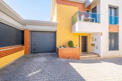 a yellow and white house with a garage at Cozy villa with pool and Barbecue in Albufeira