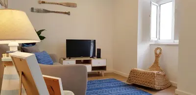a living room with a couch and a television at Velha 34 in Albufeira
