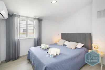 a bedroom with a bed with blue sheets and a window at Old Town - Albufeira - Dream Lodging in Albufeira