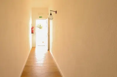an empty hallway with a white door and wooden floors at Apartamentos Pedro for Families by Bedzy in Albufeira