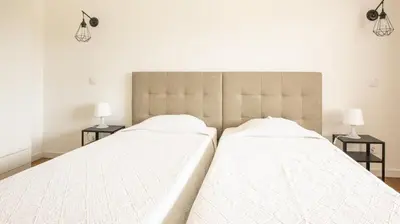 two beds in a bedroom with two lamps on tables at Apartamentos Pedro for Families by Bedzy in Albufeira