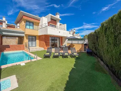 a house with a swimming pool and two yellow chairs at V4, Villa Jardins Branqueira near Beach, Albufeira in Albufeira