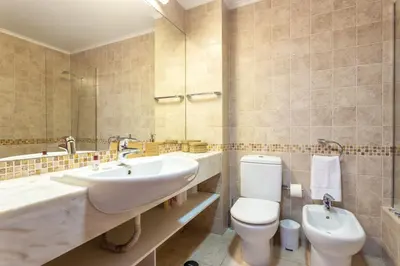 a bathroom with a sink and a toilet and a mirror at Host Wise - Bright Cozy Flats w Terrace & Pool in Quarteira