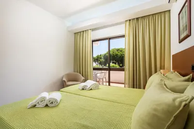 a hotel room with two beds with towels on them at Host Wise - Bright Cozy Flats w Terrace & Pool in Quarteira