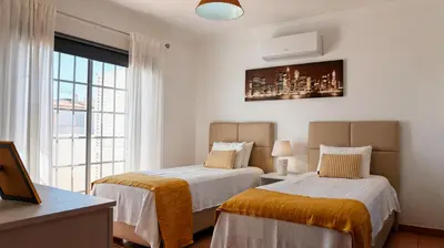 a bedroom with two beds and a window with a view at Villa do Mar - Galé in Albufeira