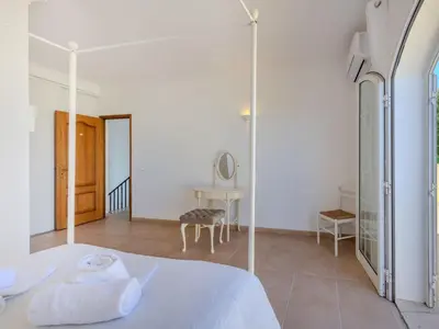a white bedroom with a bed and a mirror at Villa Villa Monte da Torre by Interhome in Loulé