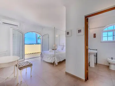a bedroom with a bed and a bathroom with a sink at Villa Villa Monte da Torre by Interhome in Loulé